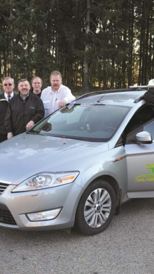 En bil med taxireklame på en gresslette