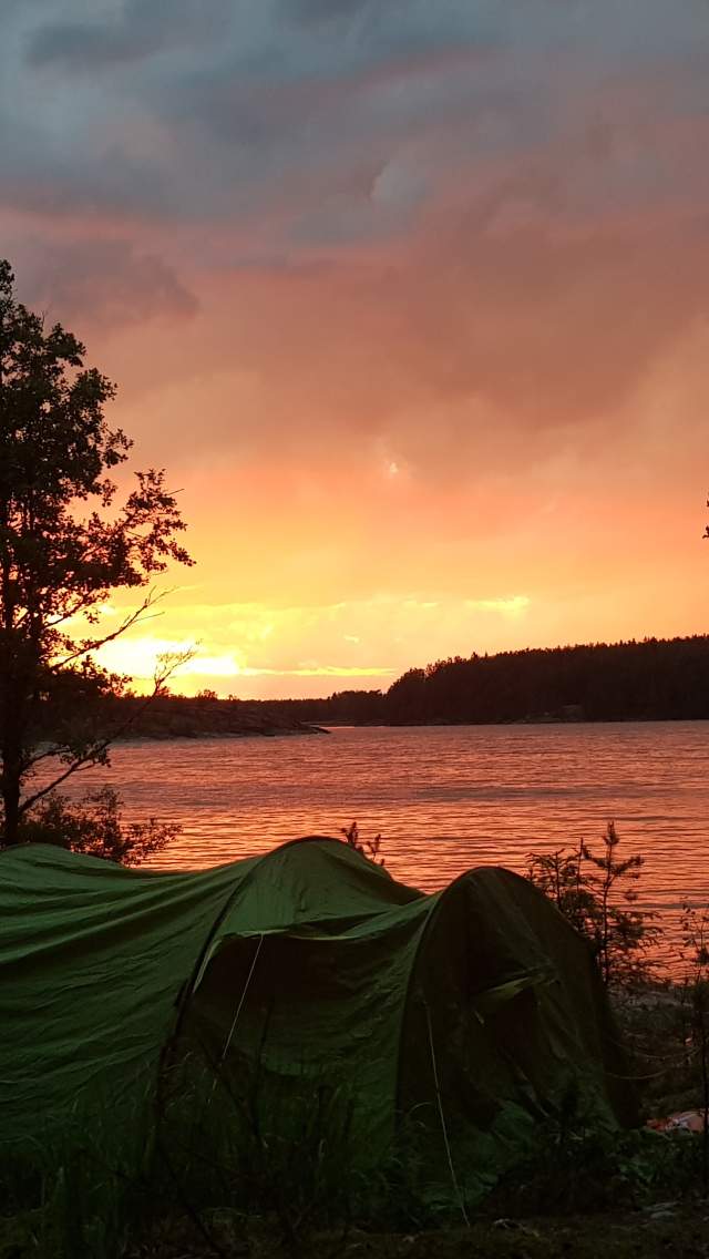 Telt i Vansjø med solnedgang