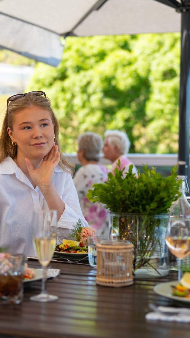 tTe jenter sitter ute å spiser et deilig måltid på Sluseporten Båtcafé på Ørje
