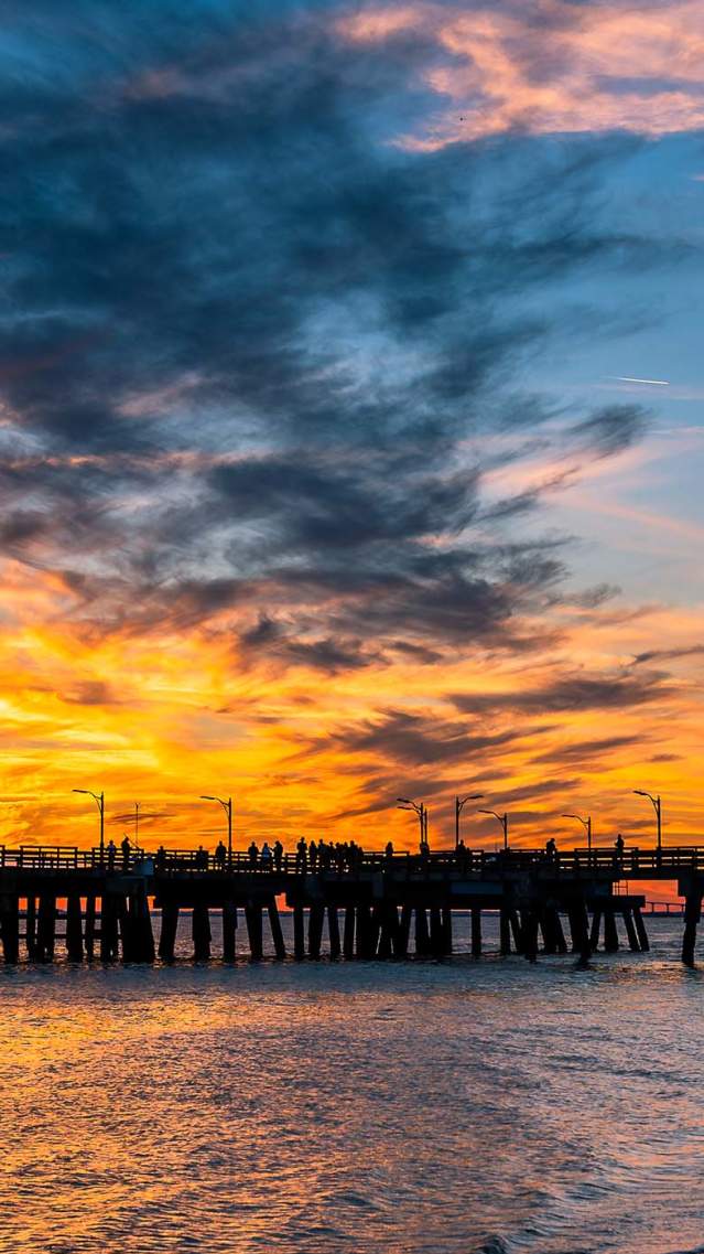 The sun sets behind the St. Simons Island Fishing Pier, a popular attraction on St. Simons Island, GA