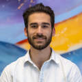 A headshot of Paul Stannard in front of a colorful background at the Visit Syracuse office.