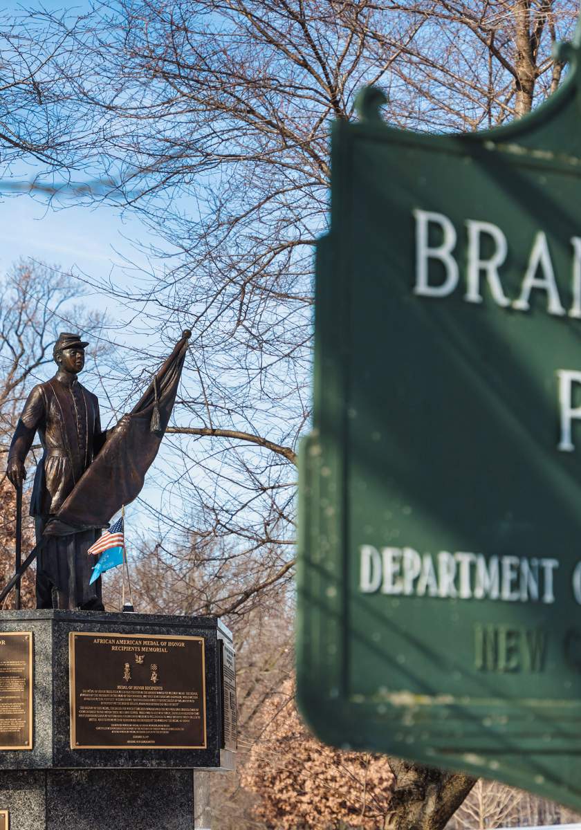 Bronze sculpture of two African American soldiers in the background, with Brandywine Park sign in the foreground