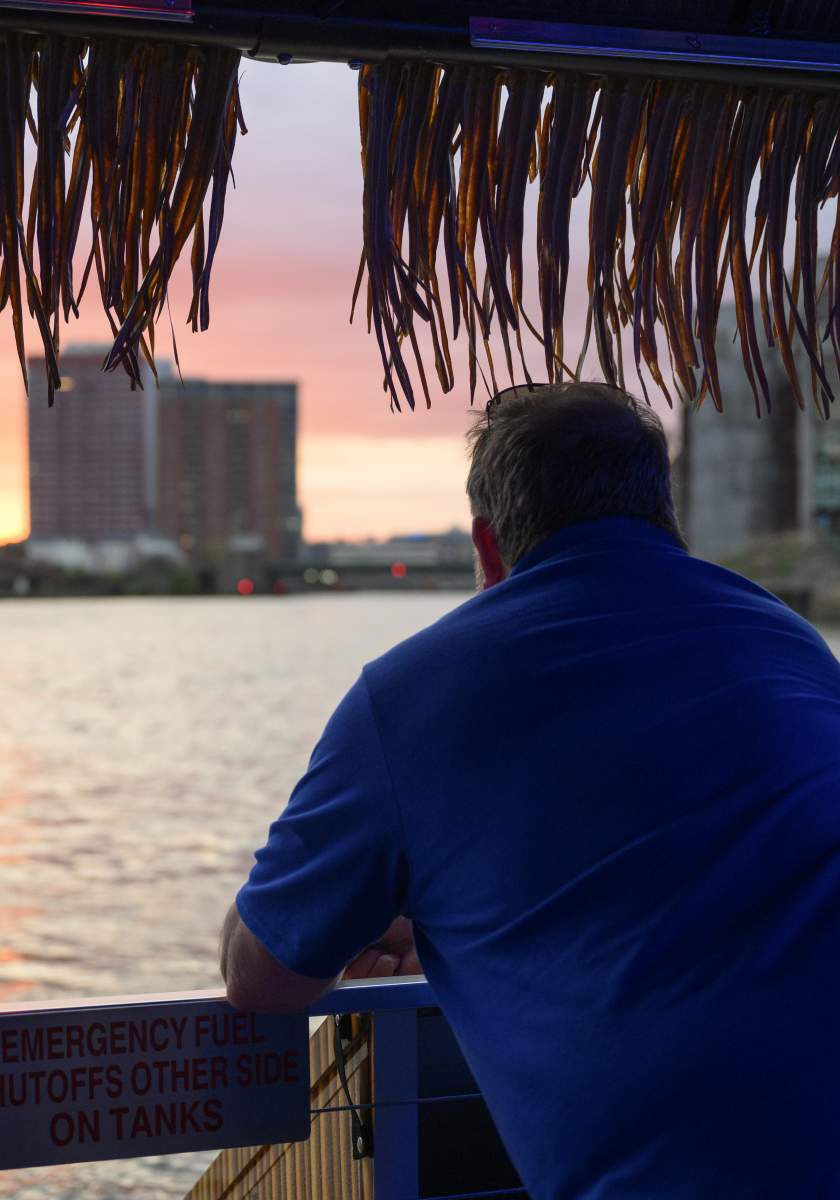 Man and woman looking out over the riverfront at sunset