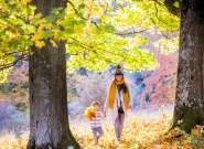 A mother and her young daughter in the grounds of Westonbirt Arboretum near Bristol in autumn - credit Johnny Hathaway