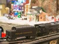 A model train rides through a Christmas Village
