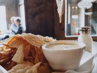 beer cheese dip dripping from chip
