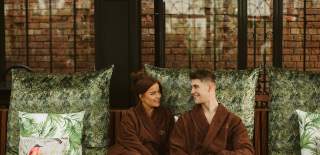 A young couple sitting in robes at The Galgorm Spa