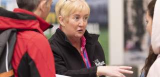 Woman talking to people at Visit Belfast Welcome Centre