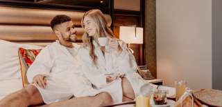 Couple enjoying breakfast in bed at Grand Central