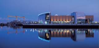 SSE Arena Belfast overlooking the water with Harland and Wolff in the background.