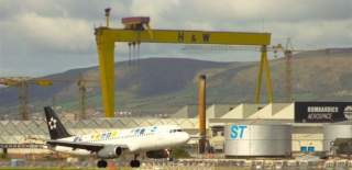 Photo of plane at belfast city airport taking off, with harland and wolff in the background.