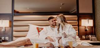 Couple having breakfast in bed at the Grand Central Hotel in Belfast