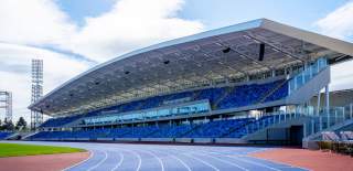 Alexander Stadium athletics stadium blue running track in front of matching two-tier stand seating.