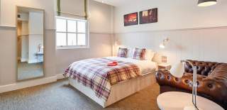 A double bed with leather sofa in bed and breakfast accommodation