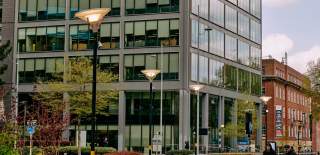 Looking across a square to the foot of a skyscraper