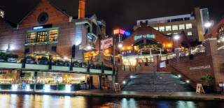 A collection of restaurants in Brindleyplace, taken at night across the water of the canal.
