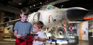 Two young boys reading an information booklet inside The Aerospace Galleries at Aerospace Bristol - credit Aerospace Bristol