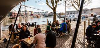 People sitting on the outdoor tables at the Arnolfini Harbourside Bar on Bristol's Harbourside - credit Arnolfini Bristol