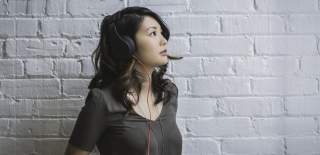 A woman wearing headphones listening to the Bristol audio tour