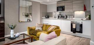 A yellow sofa in the kitchen of Beech House - Credit Urban Apartments