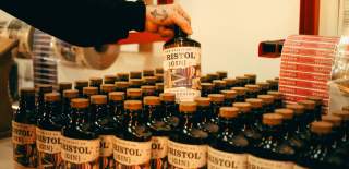 Person picking up a bottle of gin - credit The Spirit of Bristol
