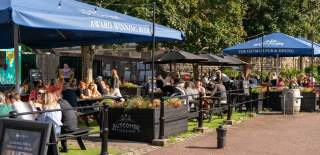 People sitting outdoors under the sun by The Ostrich pub in the Redcliffe area of Bristol - credit Mahtola Eagle