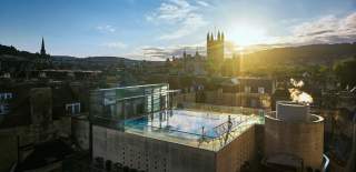 An aerial view of the rooftop pool at the Thermae Bath Spa in central Bath, with Bath's skyline in the background