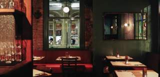 Restaurant interior with red booths and low lighting at Flat Iron in Bristol
