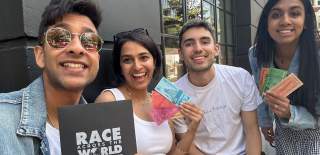 Group posing with items from Race Across the World: The Experience