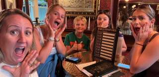 Family posing with items from Race Across the World: The Experience
