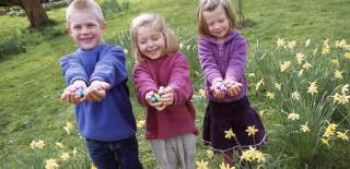Children holding chocolate Easter eggs in the grounds of Dyrham Park near Bristol