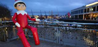 A giant inflated elf sat on a bridge - Credit Plaster