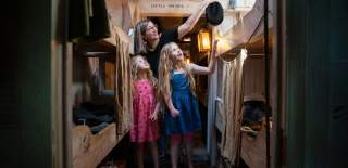 A family exploring the steerage section inside Brunel's SS Great Britain, Bristol - credit Brunel's SS Great Britain