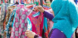 A woman hanging clothes on a rack on her stall at Bristol's Islamic Festival