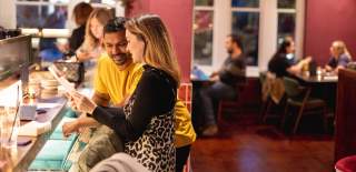 Couple sat at bar in restaurant