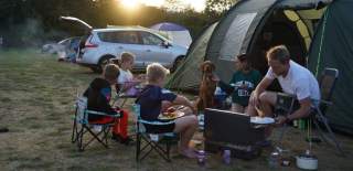 A family sat around a campfire - Credit Mendip Activity Centre