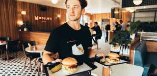Person carrying burgers at Mollies Motel & Diner Bar in North Bristol - credit Mollies Motel & Diner Bar