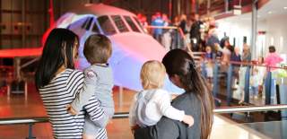 Two mothers and their children looking at the nose of Concorde Alpha Foxtrot in the Concorde Hangar at Aerospace Bristol - credit Aerospace Bristol