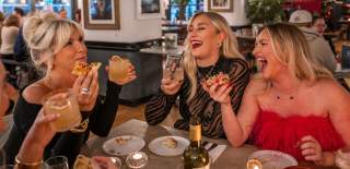 Group of friends having a laugh around a dinner table