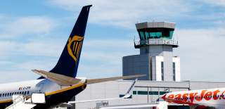 Airplanes in the foreground with an Air Traffic Control tower in the background - Credit Bristol Airport