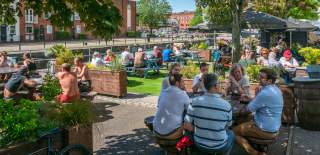 People sitting outdoors under the sun by The Ostrich pub in the Redcliffe area of Bristol - credit Mahtola Eagle