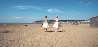 A newly married couple holding hands on the beach at Weston-super-Mare near Bristol - credit Charlotte Harris