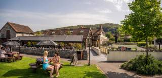 People sitting outside under the sun next to the Railway Inn at Thatchers Cider HQ in Sandford, near Bristol - credit Thatchers