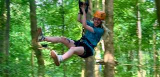 Person on zip line in tree tops - credit Adventure Bristol