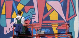 David McMillian painting a mural at Upfest street art festival in Bristol