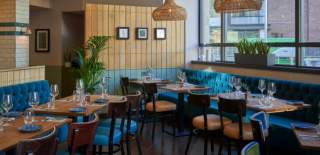 Restaurant interior with blue banquets and small tables