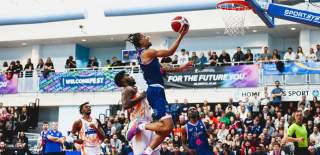 A man wearing an all blue basketball uniform dunking a basketball - Credit Bristol Sport