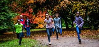 A family running through the grounds of Westonbirt Arboretum near Bristol in autumn - credit Johnny Hathaway