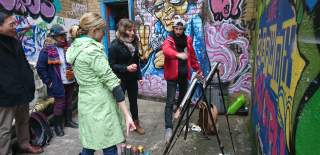 A group having a go at creating street art on the Where the Wall tour in central Bristol - credit Where The Wall
