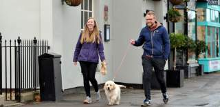 Visitors walking their dog outside The Suffolk Arms in Cheltenham.